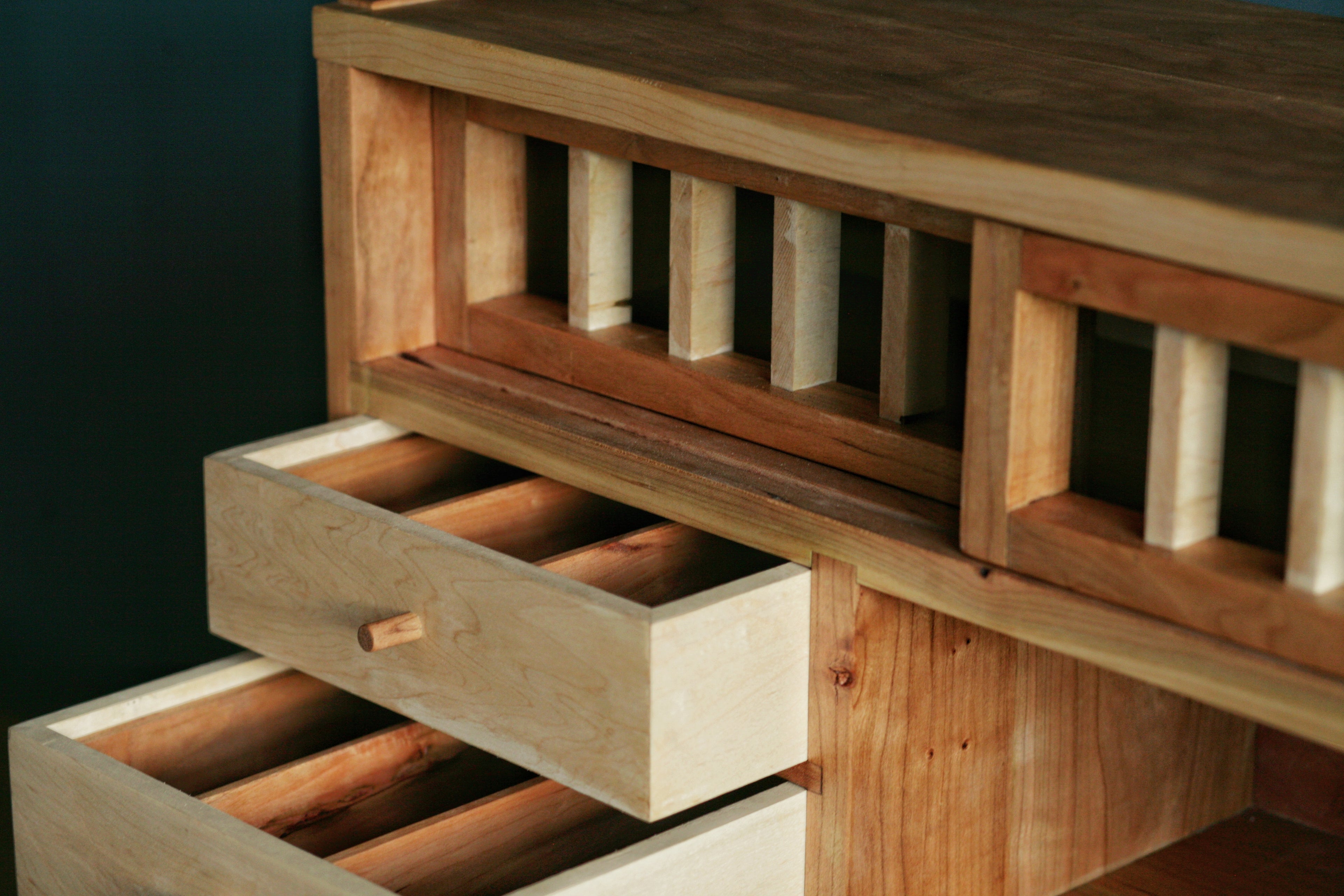 Wooden drawer unit with a dark background.
